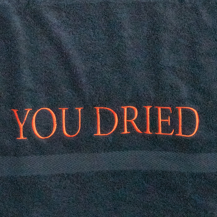 Close-up of the red embroidered "YOU DRIED" lettering
