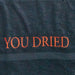 Close-up of the red embroidered "YOU DRIED" lettering